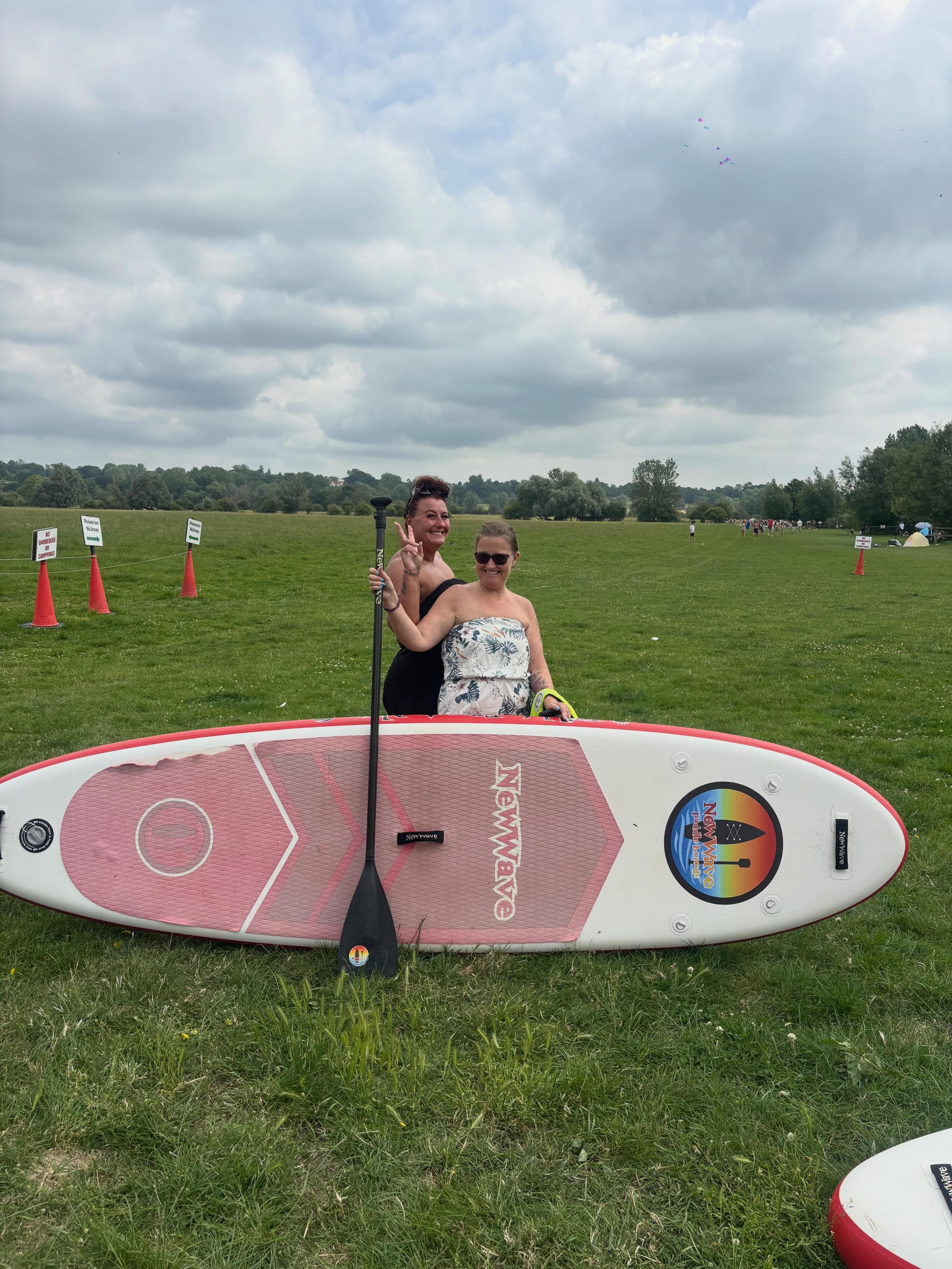 Two happy paddlers with a red NewWave board