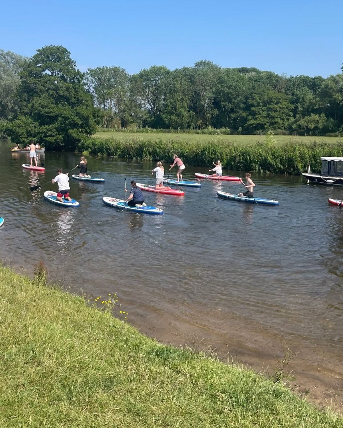 A group paddleboarding along the River Stour at Dedham
