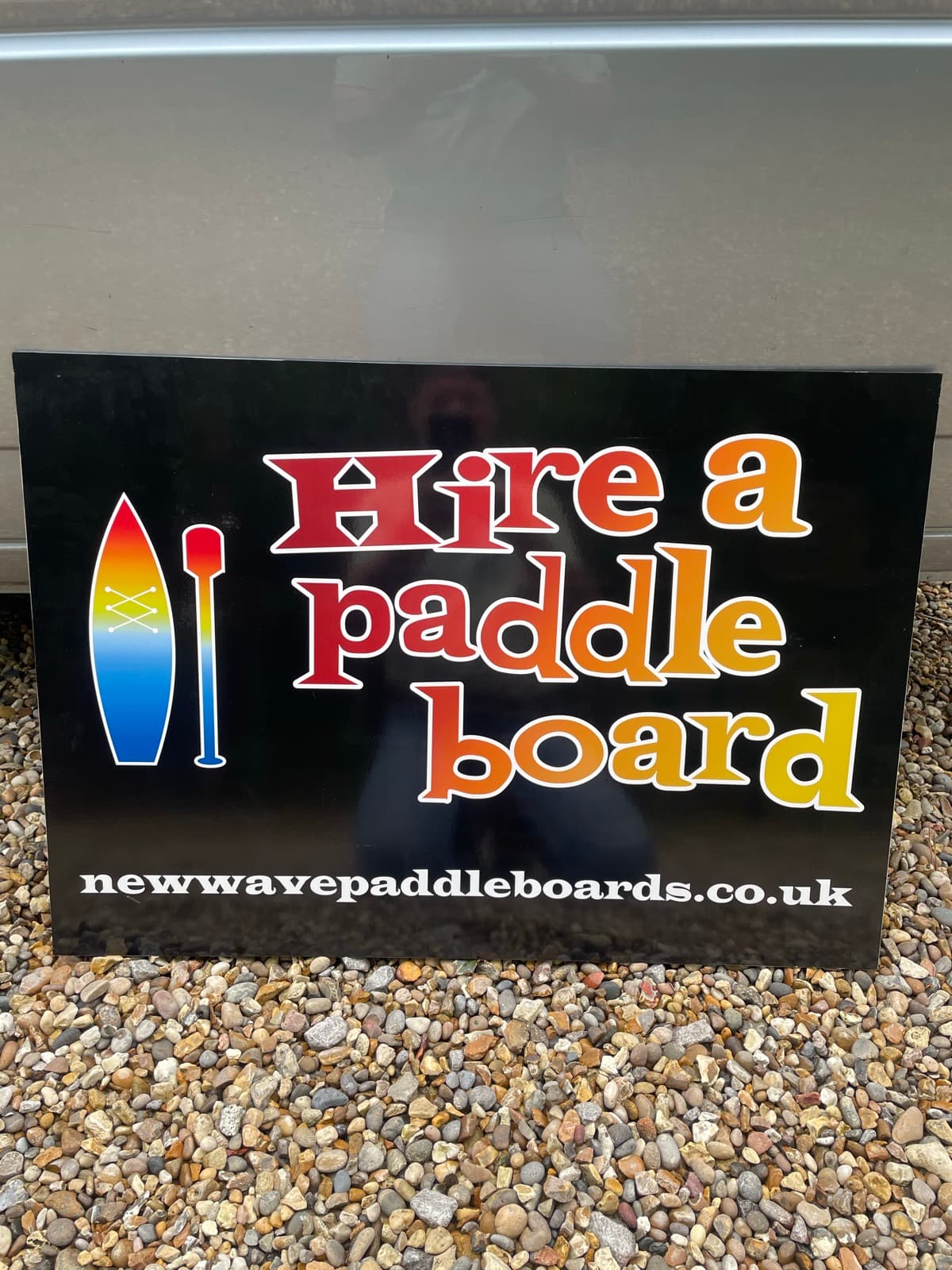 The 'Hire a paddle board' sign at the meadow