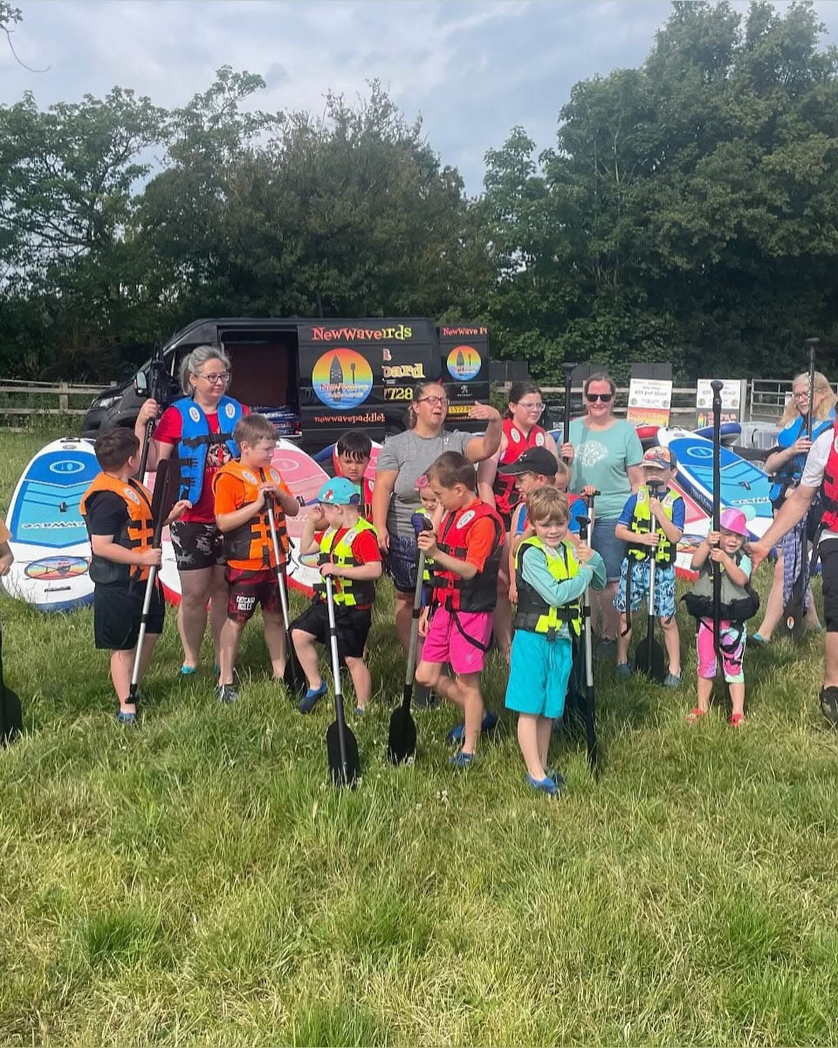 Kids' paddle club group holding paddles